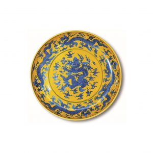 a blue and white dragon dish on yellow ground