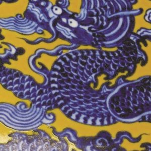 a blue and white dragon dish on yellow ground